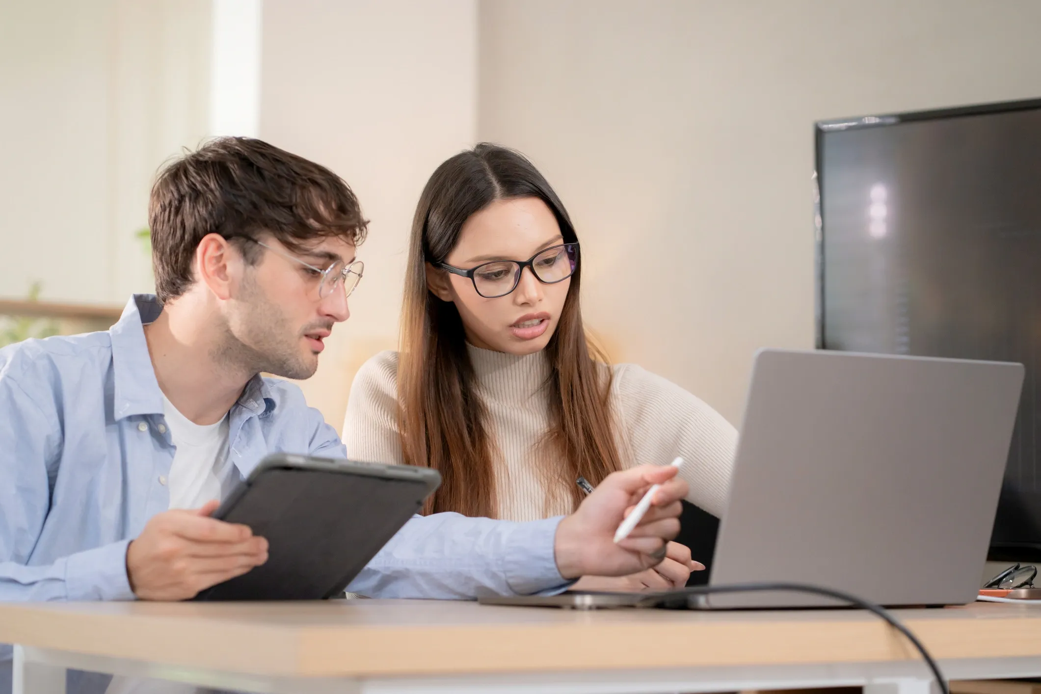 Two colleagues collaborating at a laptop